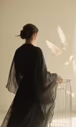 a woman with long sleeves and a birdcage