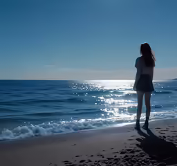 a woman on the beach watching the ocean