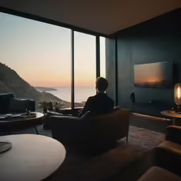 man sitting in chair watching television in his living room