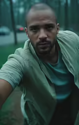 a man posing for the camera while in a park