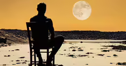 a silhouetted man sitting in a chair while watching the full moon