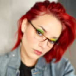 a girl wearing glasses with red hair and eyeliners