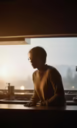 man with glasses looking out a window at the snow covered mountains