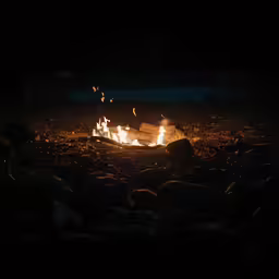 a fire in the dark with some flames lit up