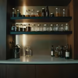 a shelf with bottles and a pitcher on it