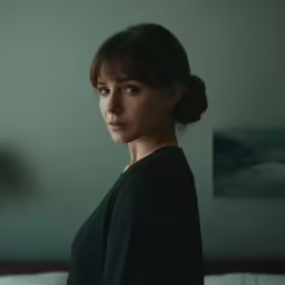 a woman is sitting on a bed with blue eyes