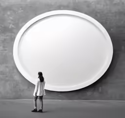 a woman standing by an art display round shaped white object