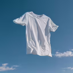 a white t - shirt is hanging on a clothes line