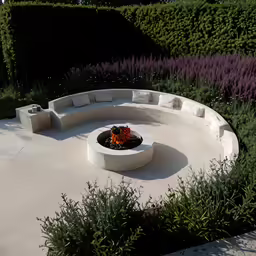 a cement bench sitting next to green bushes