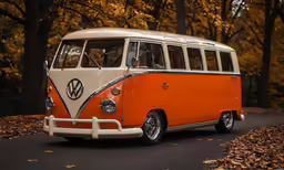 an orange and white volkswagen bus parked on a road