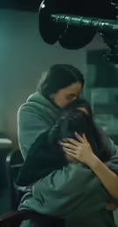 a woman hugging a person wrapped in a blanket