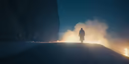 the silhouette of a man standing alone in front of fire