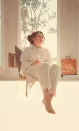 a woman is sitting in a chair and looking out the window