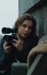 a beautiful woman holding a camera in her hands