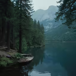 small boat sitting by the edge of the calm lake