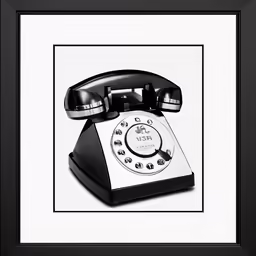 an old fashioned phone sitting in front of a black and white frame