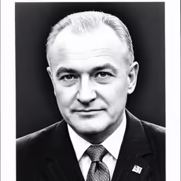 a black and white photo of a man in suit and tie