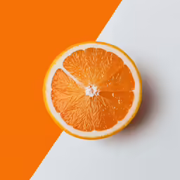 an orange that is sitting on a white and orange surface
