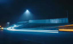 a street with cars moving at night on the side
