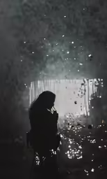 a woman in black sitting in a chair next to trees