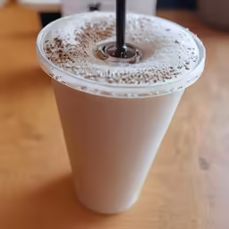 an iced drink in a plastic cup with black lid