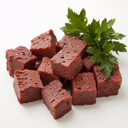 a small group of fudge chocolate squares next to a plant