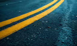 wet road markings, with rain drops and car going by