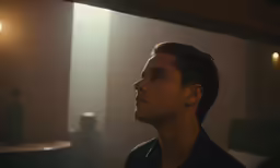 a man staring away in the dark of the night