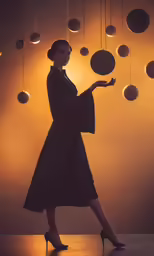 woman in black dress, ball ornaments above her head and one hand with a raised index index