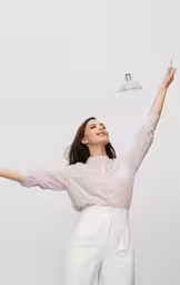 a woman in a white blouse holding up an object