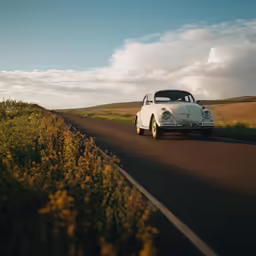 an old vw bug driving down the road