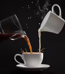 liquid pouring from a white cup into a teacup