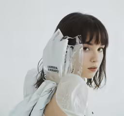 a woman holding her gloves to protect her head and arm