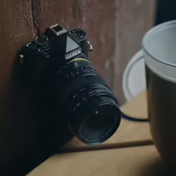 a camera is laying next to a mug