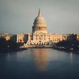 a capitol building sitting at night with its lights on