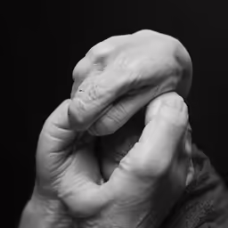 a man holding his hand up to his face