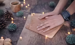 someone holding their hands on a small cutting board