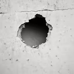 an abstract hole in a concrete surface showing holes and stains