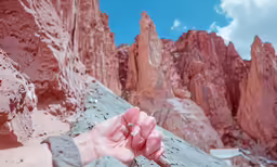 a person holding something with one hand while standing on a snow covered mountain