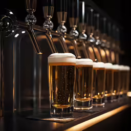 glasses of beer are lined up on a bar