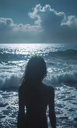 there is a woman that is standing in the ocean