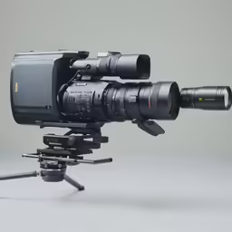 a camera sitting on top of a tripod next to a video camera