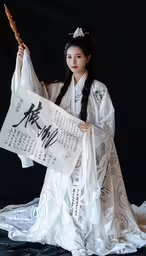 an oriental girl in traditional costume holding a sheet,woman in white and black holding up an oriental scroll