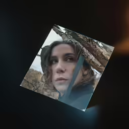 an old woman looks at the camera through a glass