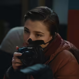 a woman holding up a camera next to her face