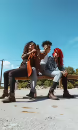 two young women are sitting on a bench
