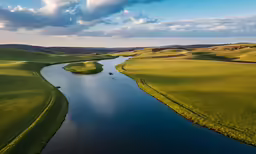 this is an aerial view of a beautiful green field and lake