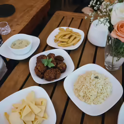 four different plates of food are on a wood table