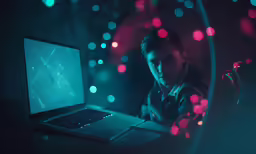 man looking at laptop screen and neon lights