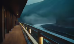 the balcony of a building with people looking at a body of water